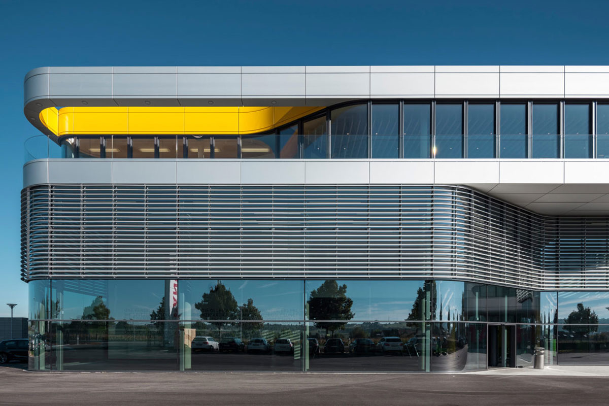 Localizada em Neuhausen, no sul da Alemanha, Academia Fanuc, tem uma estrutura clara, toda envidraçada, com parte revestida que atua não apenas como proteção solar, mas também promove ventilação natural e extração de ar, além de proporcionar isolamento acústico.