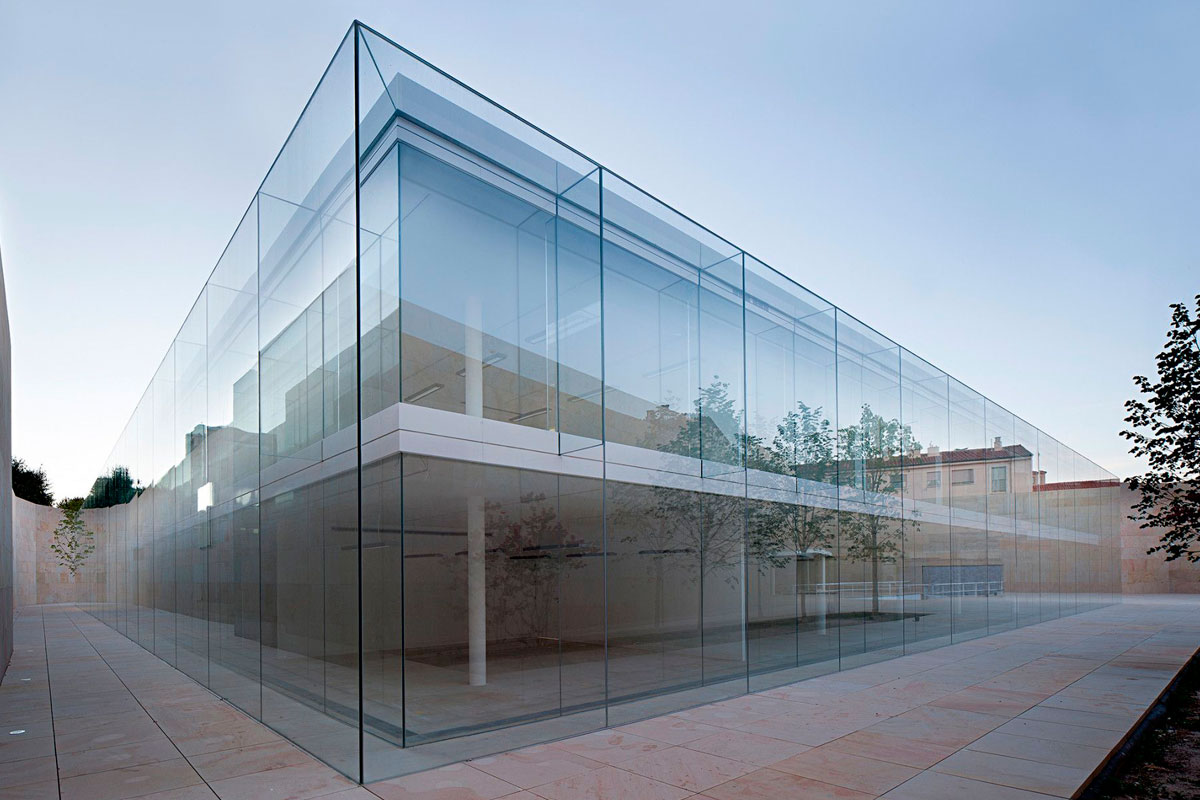 A fachada do Zamara Offices, construído na cidade espanhola de mesmo nome, é toda transparente, com chapas de vidro 6000 x 3000 unidas com silicone estrutural e com o mínimo de interferência visual. Os ângulos superiores tridimensionais da caixa são feitos completamente com vidro, acentuando ainda mais o efeito da transparência. O projeto é de Alberto Campo Baeza.