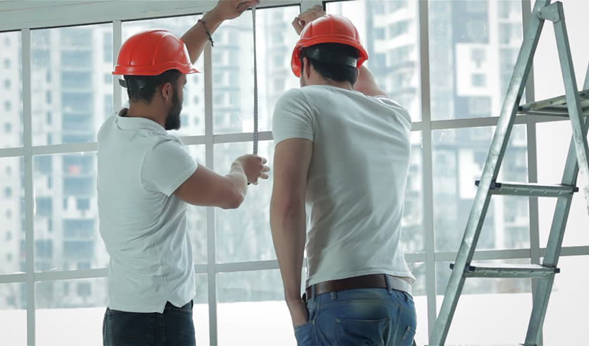 dois vidraceiros instalando uma janela