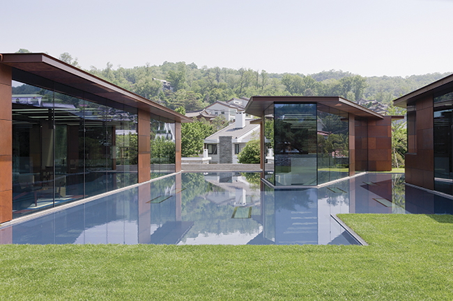 O espelho d’água exerce função simultânea de conectar e dividir os pavilhões envidraçados